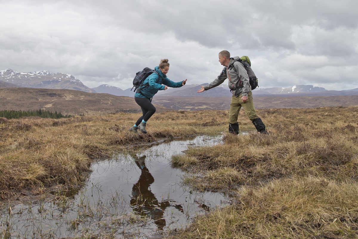 Client and guide on a days mountain guiding jumping over a puddle